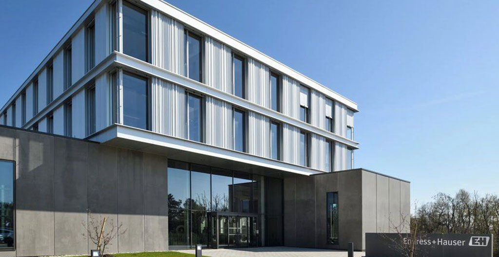 Façade moderne d'entreprise avec mur végétal et toiture verte, passants urbains au premier plan regardant le bâtiment